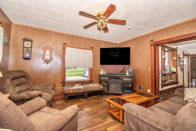 living room featuring ornamental molding, wood walls, ceiling fan, vaulted ceiling, and hardwood / wood-style flooring