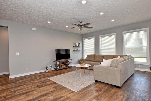 living room with dark hardwood / wood-style floors, ceiling fan, and a textured ceiling