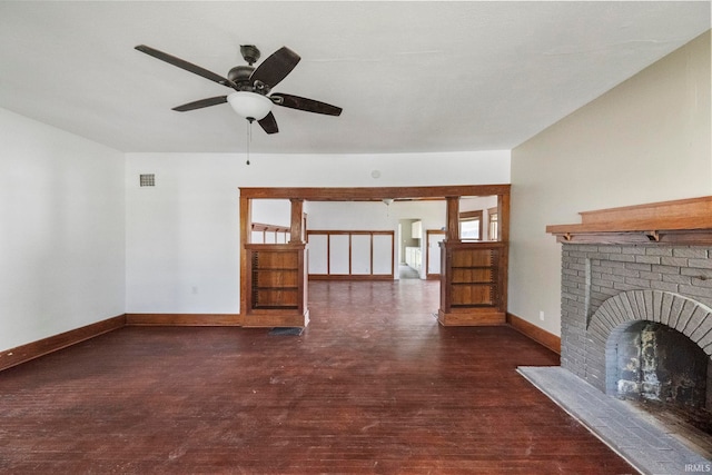 unfurnished living room featuring wood finished floors, ceiling fan, baseboards, and a brick fireplace