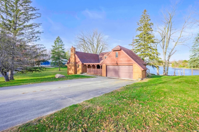 view of front of property with a water view, a garage, and a front yard