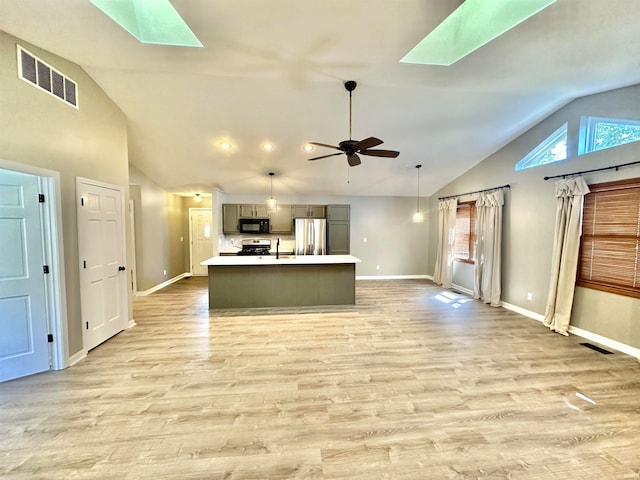 kitchen with gray cabinetry, stainless steel fridge, light hardwood / wood-style flooring, a skylight, and ceiling fan