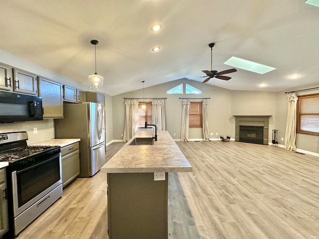 kitchen featuring light wood-type flooring, ceiling fan, sink, and appliances with stainless steel finishes