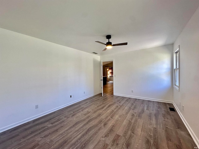 empty room featuring ceiling fan and dark hardwood / wood-style flooring