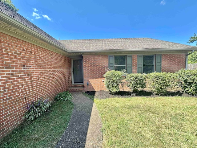 doorway to property with a lawn