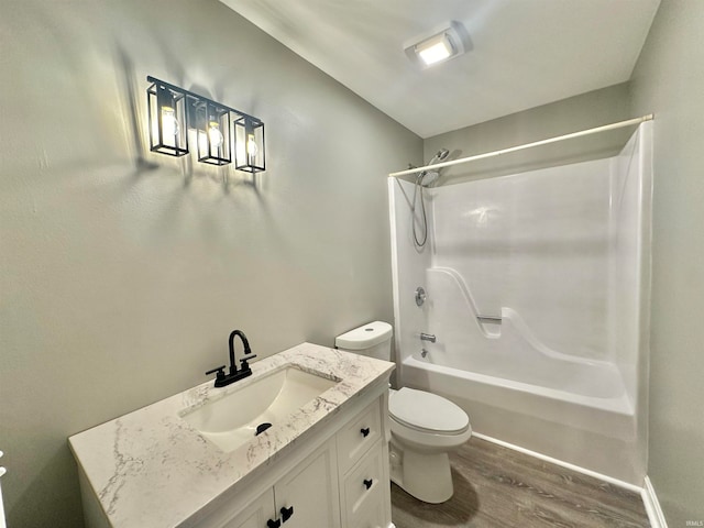 full bathroom featuring vanity, toilet, washtub / shower combination, and hardwood / wood-style flooring