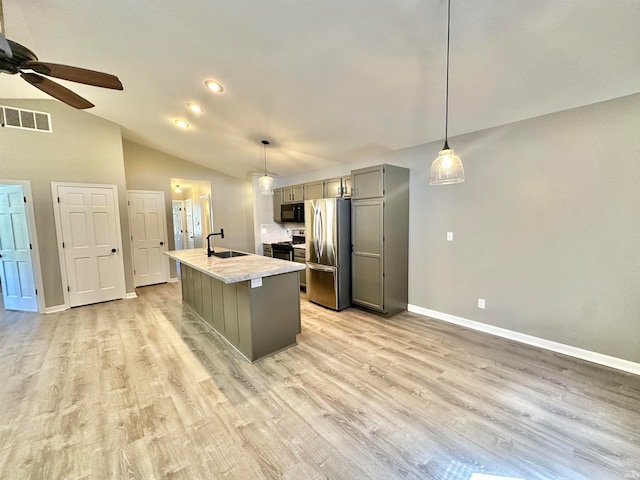 kitchen featuring stainless steel appliances, lofted ceiling, gray cabinets, an island with sink, and ceiling fan