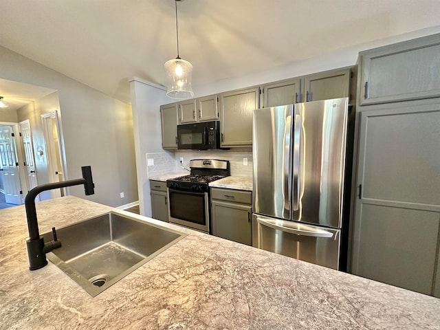 kitchen featuring hanging light fixtures, backsplash, vaulted ceiling, appliances with stainless steel finishes, and sink