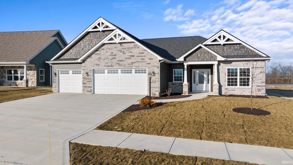 craftsman house featuring a front lawn and a garage