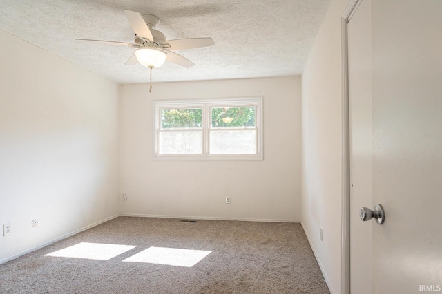 carpeted spare room featuring ceiling fan and a textured ceiling