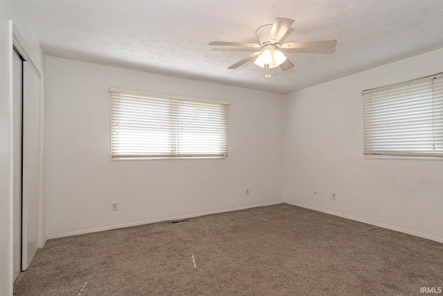 carpeted empty room with a textured ceiling and ceiling fan