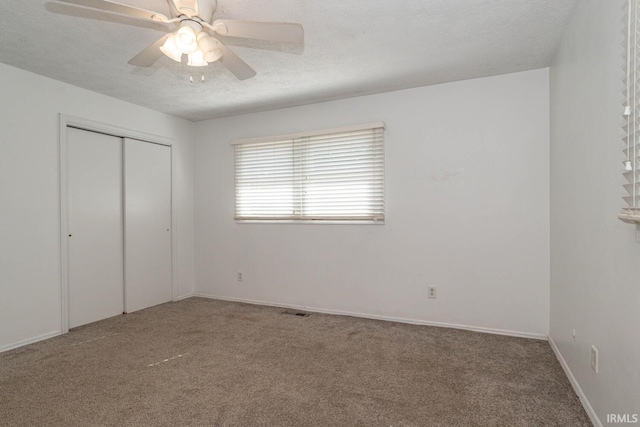 unfurnished bedroom featuring a closet, a textured ceiling, ceiling fan, and carpet flooring