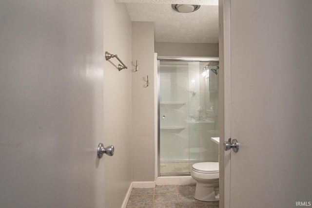 bathroom featuring a textured ceiling, toilet, walk in shower, and tile patterned flooring