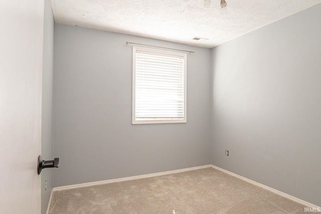 empty room with a textured ceiling and carpet flooring