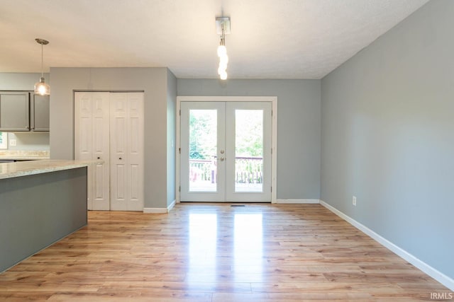 unfurnished dining area with light hardwood / wood-style flooring and french doors