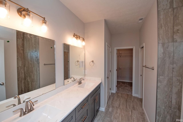 bathroom with vanity, hardwood / wood-style flooring, and a textured ceiling