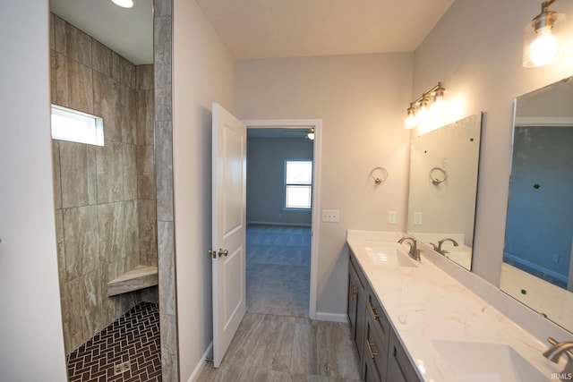 bathroom featuring vanity, hardwood / wood-style flooring, and a tile shower