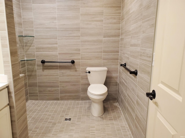 bathroom featuring a tile shower, vanity, and toilet