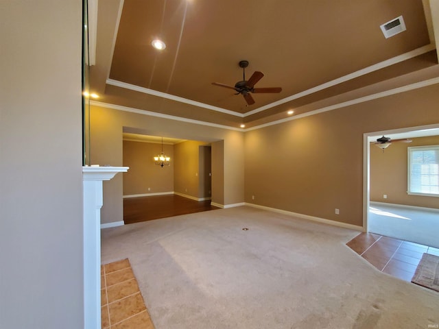 unfurnished room with carpet floors, ceiling fan with notable chandelier, and a raised ceiling