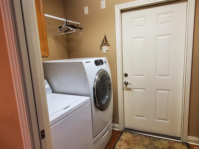 clothes washing area with washing machine and dryer and cabinets