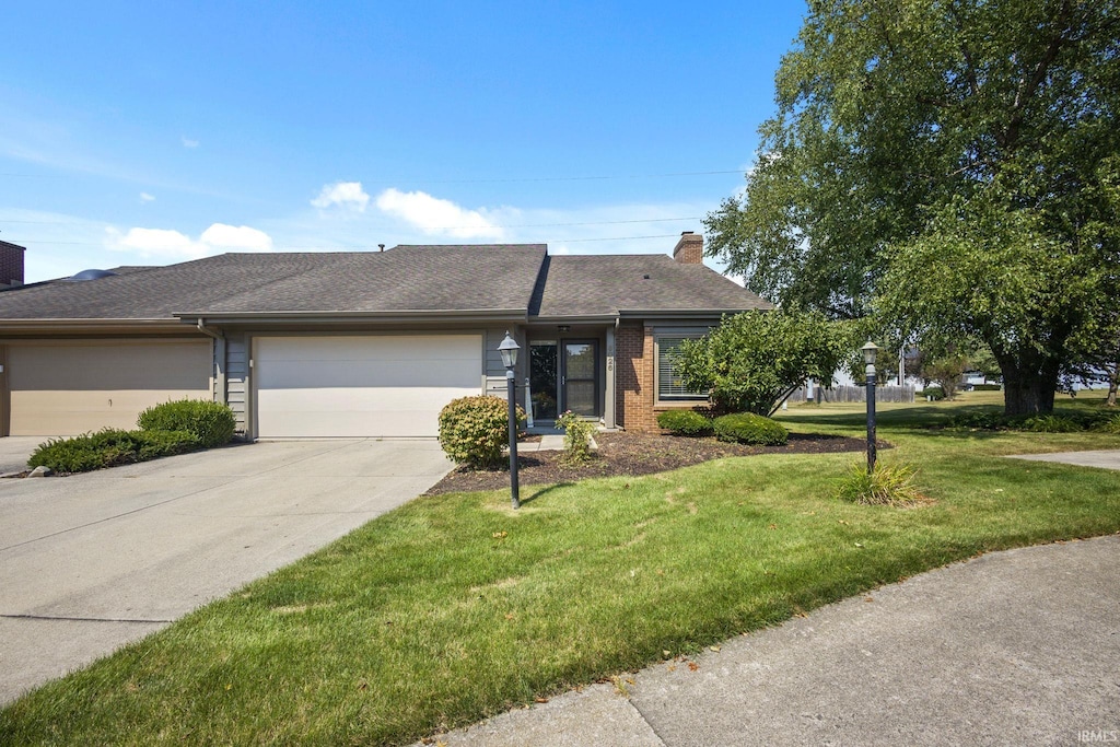 ranch-style house featuring a garage and a front yard