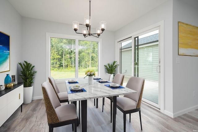 dining area featuring a wealth of natural light, a notable chandelier, and light hardwood / wood-style floors