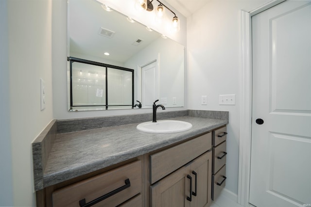 bathroom featuring walk in shower and vanity