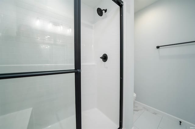 bathroom with a shower with shower door and toilet