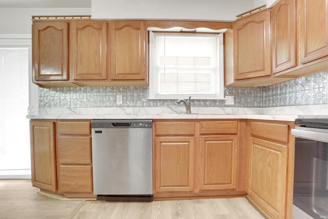 kitchen with sink, appliances with stainless steel finishes, decorative backsplash, and light hardwood / wood-style floors