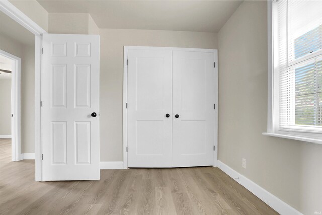 unfurnished bedroom featuring light hardwood / wood-style flooring and a closet