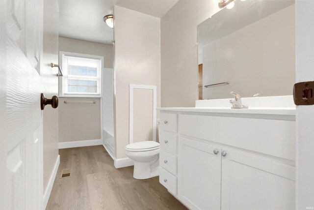 bathroom featuring toilet, hardwood / wood-style flooring, and vanity