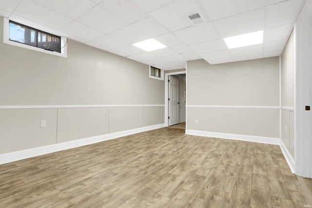 basement featuring a paneled ceiling and wood-type flooring