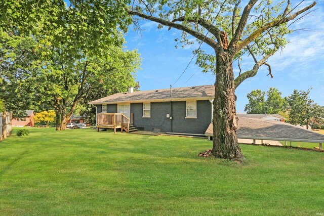 rear view of house with a yard and a deck