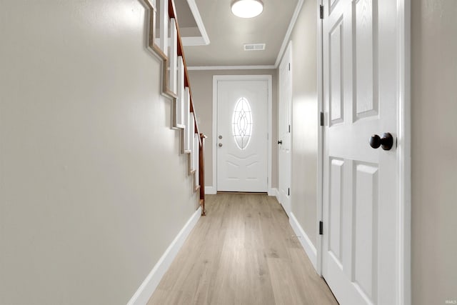 doorway to outside featuring light hardwood / wood-style flooring and ornamental molding