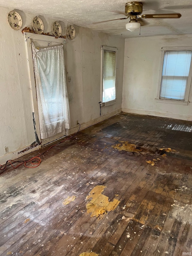 unfurnished room with dark wood-type flooring, ceiling fan, and a textured ceiling