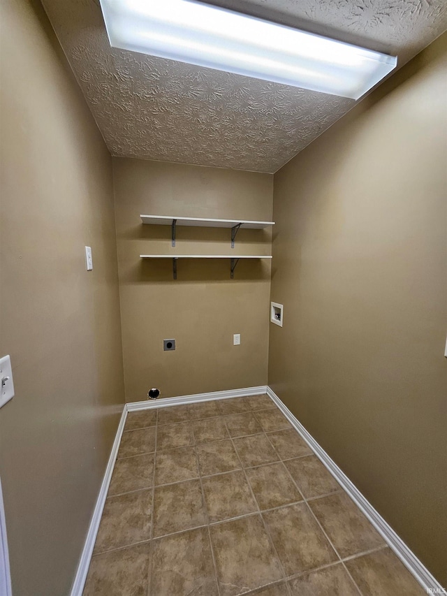 laundry room featuring a textured ceiling, hookup for a washing machine, hookup for an electric dryer, and tile patterned floors