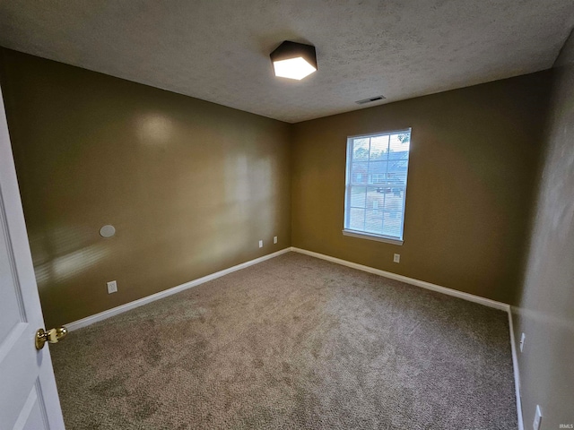 carpeted spare room featuring a textured ceiling