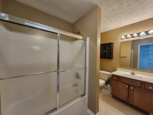 full bathroom with vanity, toilet, tile patterned floors, and a textured ceiling