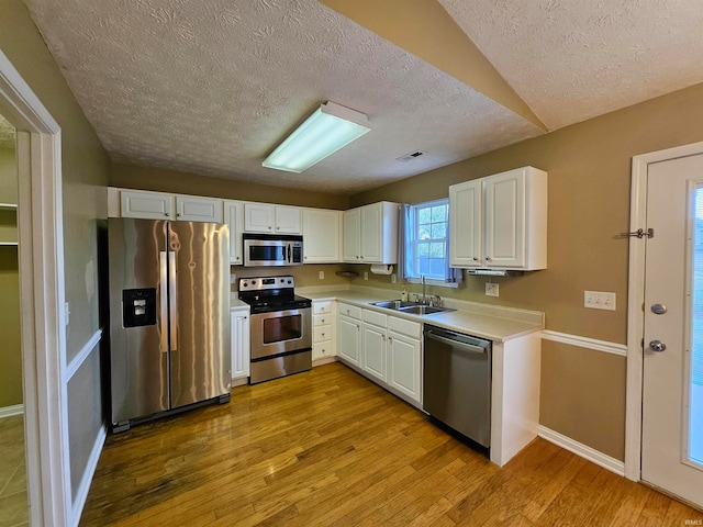 kitchen featuring light hardwood / wood-style flooring, stainless steel appliances, sink, and white cabinetry