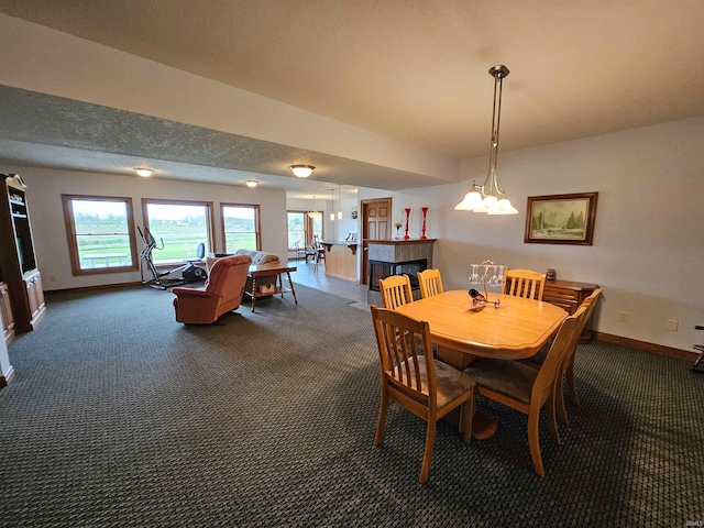 carpeted dining space featuring a textured ceiling and a multi sided fireplace