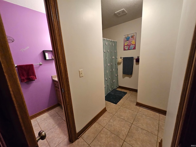 bathroom featuring tile patterned flooring, a textured ceiling, and vanity