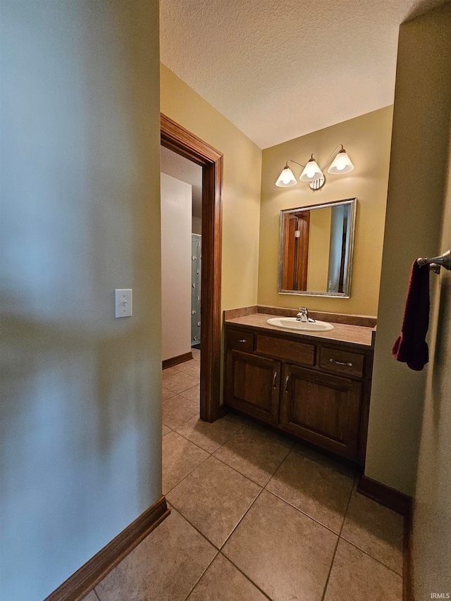 bathroom with vanity, a textured ceiling, and tile patterned flooring