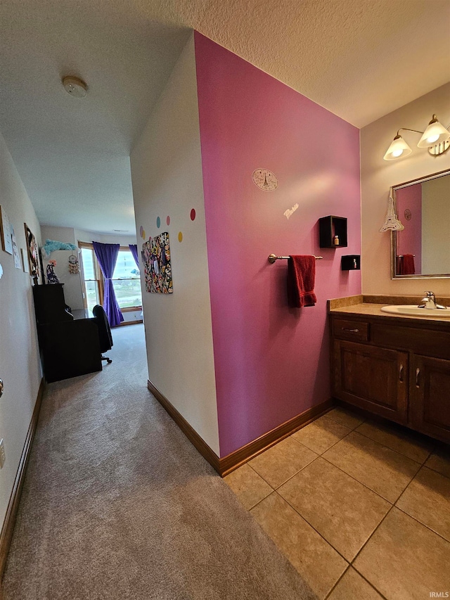 bathroom with tile patterned floors, vanity, and a textured ceiling