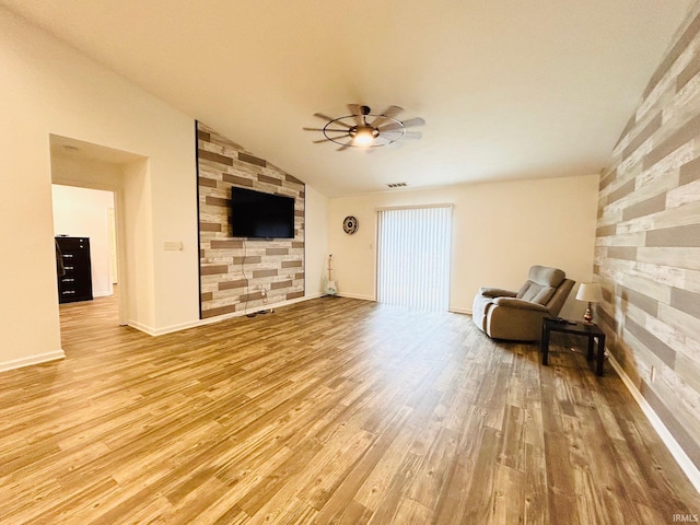 living room with ceiling fan, hardwood / wood-style flooring, and vaulted ceiling