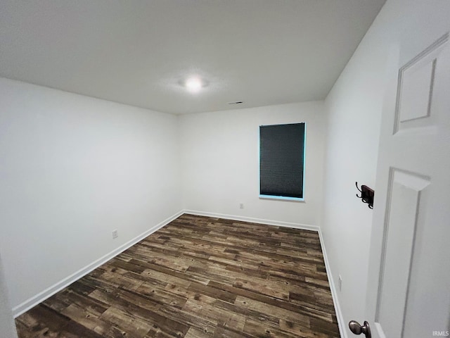 unfurnished room with dark hardwood / wood-style flooring