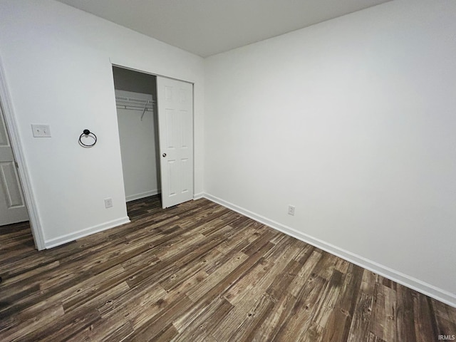 unfurnished bedroom with a closet and dark hardwood / wood-style floors