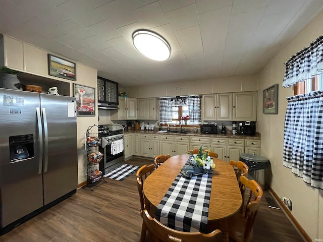 kitchen with cream cabinets, sink, appliances with stainless steel finishes, and dark hardwood / wood-style flooring