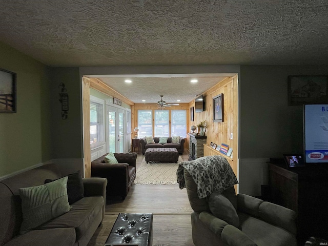 living room featuring french doors, a textured ceiling, wood-type flooring, and ceiling fan