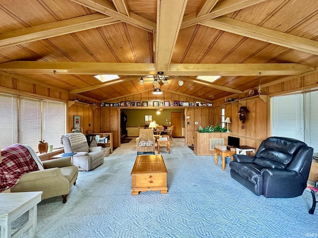 carpeted living room featuring ceiling fan, wooden walls, vaulted ceiling with beams, and wooden ceiling