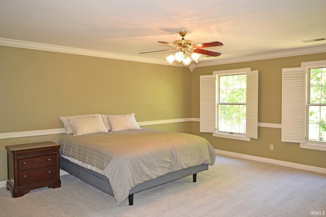 carpeted bedroom with ceiling fan, ornamental molding, and multiple windows