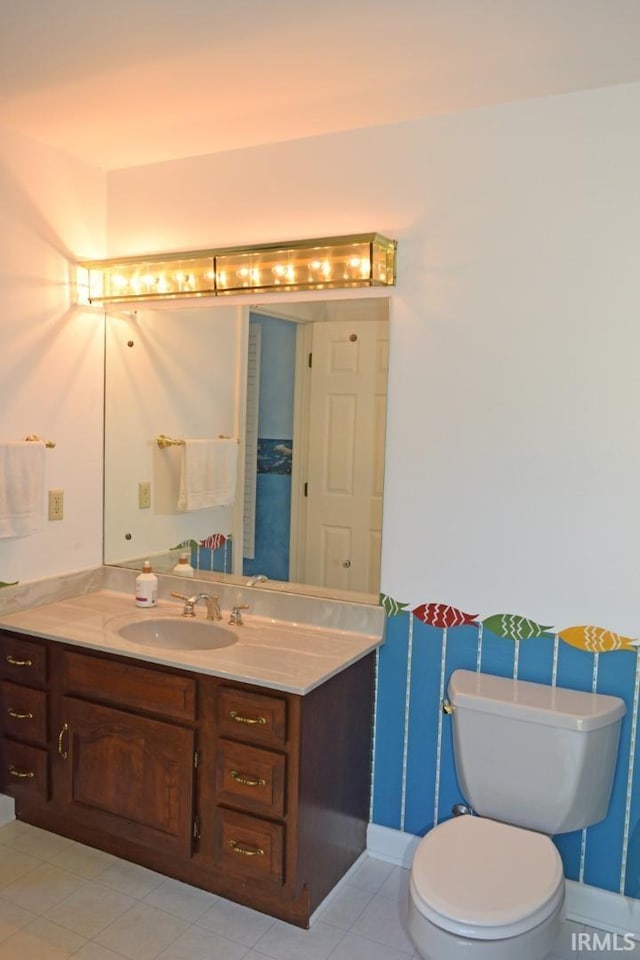 bathroom with vanity, toilet, and tile patterned floors